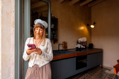 Portrait of young woman standing at home