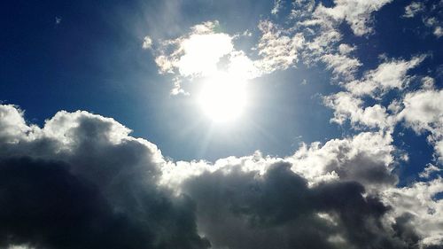 Low angle view of sun shining in sky