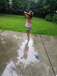 Full length of boy standing on wet grass