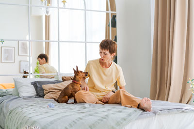 Dog training teams. happy woman training pet at home in living room, playing