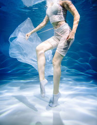 Rear view of woman standing in swimming pool