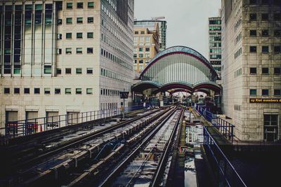 Railroad tracks amidst buildings in city