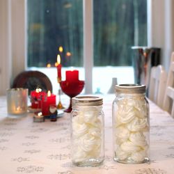 Meringues in glass jars on table