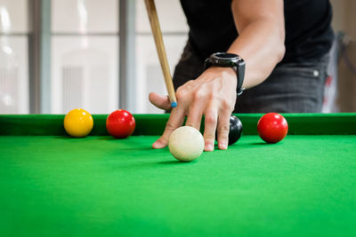 Close-up of hand playing snooker on table