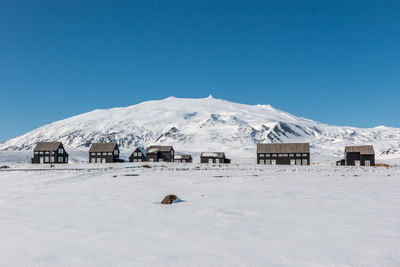 Scenic view of snowcapped mountains against clear blue sky