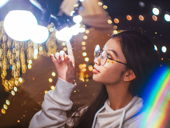 Portrait of woman holding illuminated light painting at night