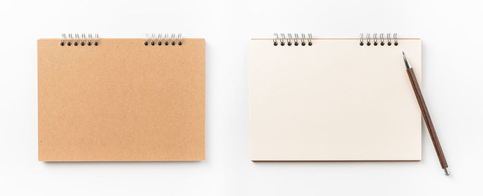 Directly above shot of spiral notebooks against white background