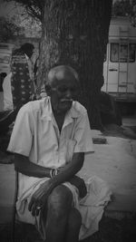 Man sitting on seat against trees