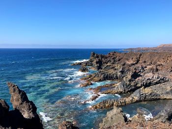 Scenic view of sea against clear blue sky