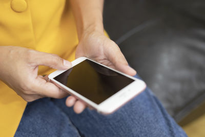 Midsection of man using mobile phone