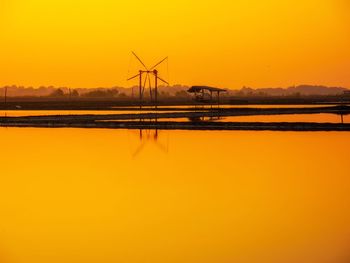 Scenic view of lake against orange sky