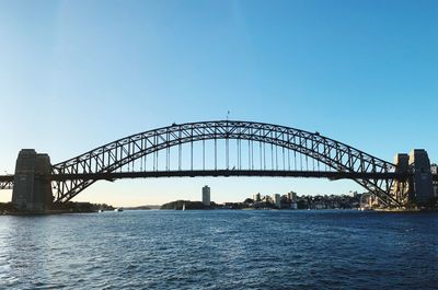 View of bridge over river against clear blue sky