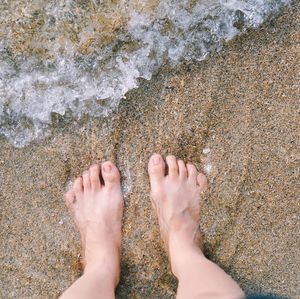 Low section of woman standing on beach