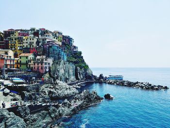 Scenic view of sea by buildings against sky