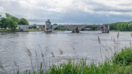 Arch bridge over river against sky