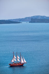 Schooner vessel ship boat in aegean sea near santorini island with tourists goes to sunset viewpoint