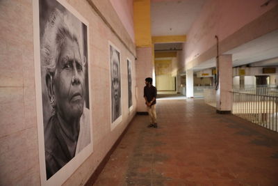 Rear view of man walking in corridor of building