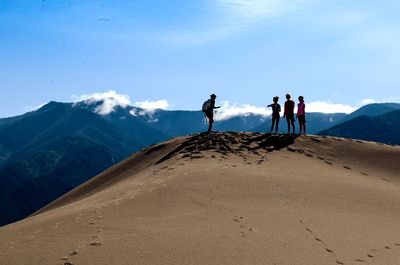 Man and women standing at great sand dunes national park and preserve