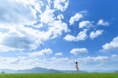 Woman standing on field against sky