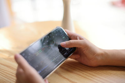 Cropped hands of woman using mobile phone