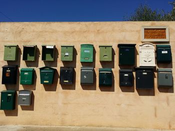 Low angle view of metallic letterboxes on wall