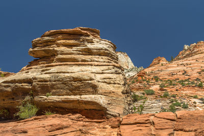 Low angle view of rock formation against clear blue sky