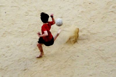 Man playing with ball on beach