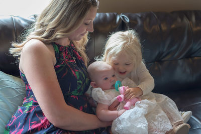 Mother with daughters on sofa at home