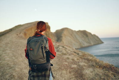 Rear view of woman looking at sea against sky