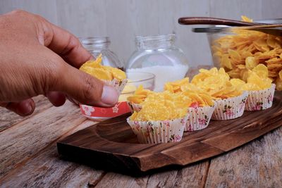 Close-up of hand holding ice cream on table