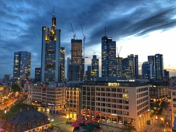 Illuminated buildings in city against sky at dusk.  frankfurt, germany