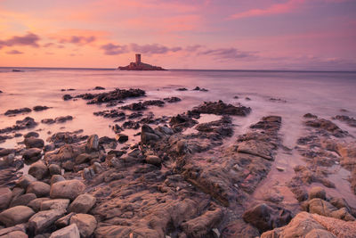 Scenic view of sea and island against sky during sunset