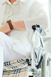 Midsection of woman sitting on chair at home