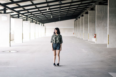 Full length of woman standing in corridor of building