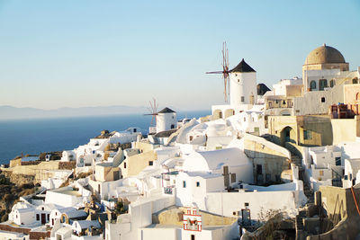 Whitewashed houses in town against clear sky