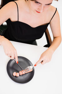 Midsection of woman holding ice cream against gray background