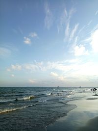 Scenic view of beach against cloudy sky