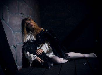 Thoughtful woman sitting in darkroom