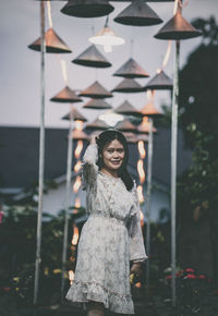 Portrait of smiling young woman standing against wall