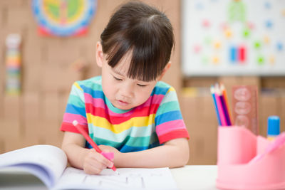 Young girl practice writing letters for homeschooling