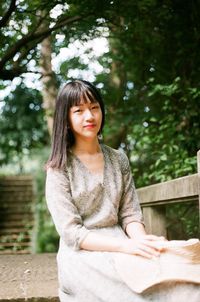 Portrait of young woman sitting outdoors