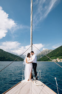 Young couple on boat in sea against sky