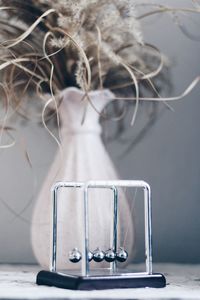 Cropped hand of woman holding in-ear headphones on table