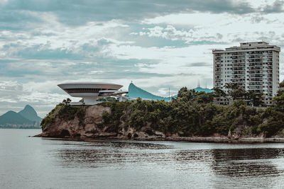 Scenic view of sea by buildings against sky