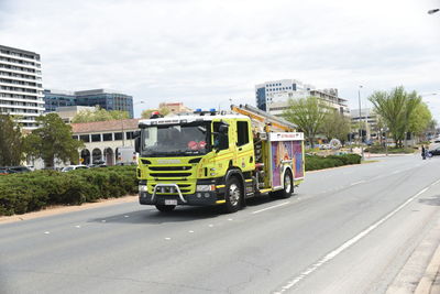 Vehicles on road in city against sky