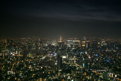 Illuminated cityscape against sky at night