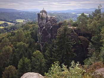 Scenic view of rock formation in forest against sky