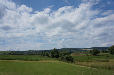 Scenic view of field against cloudy sky