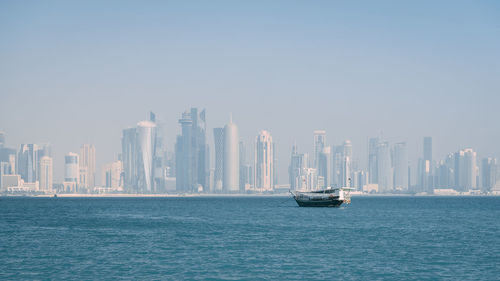 Boats sailing in sea against clear sky