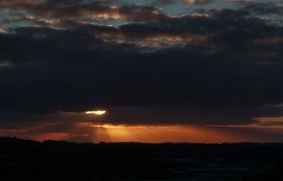Silhouette landscape against dramatic sky during sunset